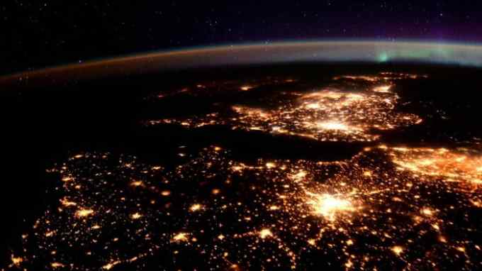 A night-time view from the International Space Station shows energy-hungry cities in the UK, France and Belgium, plus an auroral display at top