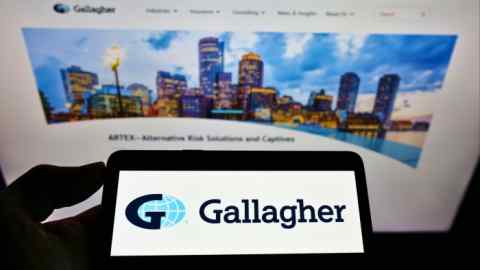 Person holding smartphone with Gallagher logo on screen