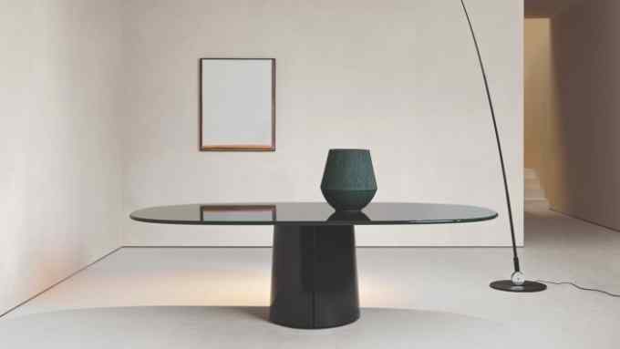 A green oval marble table with a lacquered wood base, designed by the Belgian architect Vincent Van Duysen