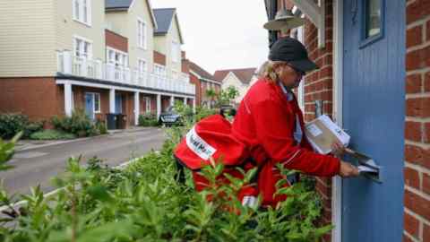 A postwoman delivers mail to a house
