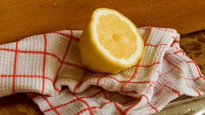 A halved lemon by a kitchen sink