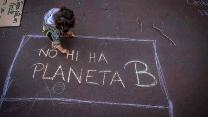 A child in Barcelona alongside graffiti reading ‘There is no planet B’