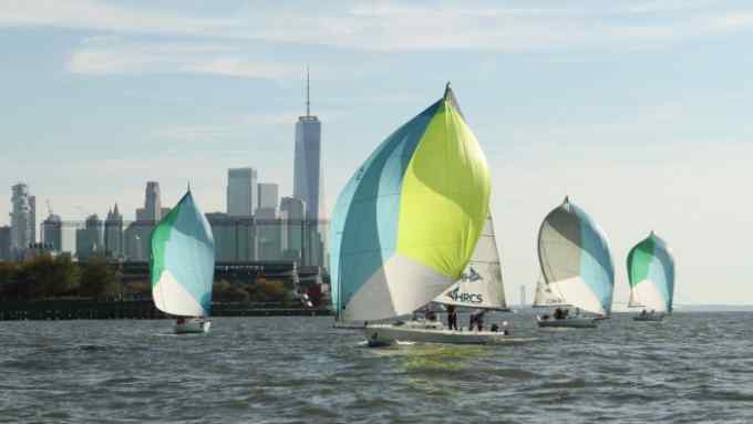 Four boats from the Hudson River Community Sailing group on the water off Manhattan, with the city skyline in the background