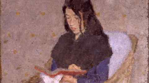 Painting of a woman with long dark hair seated in a wicker chair, reading a book