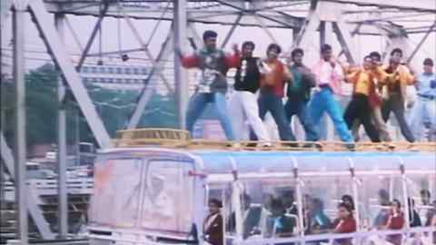 An image from an Indian film shows a line of young men dancing on the roof of a bus