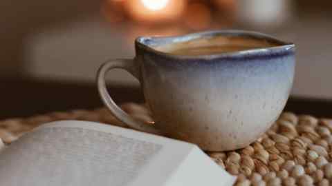 An open book and cup of coffee on a table