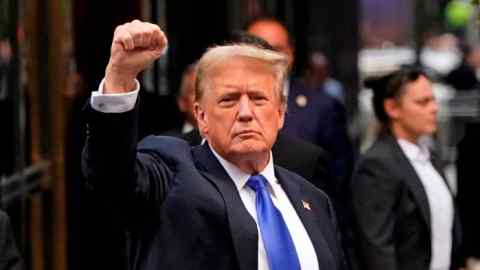 Donald Trump holds up a fist as he arrives back at Trump Tower after being convicted in his criminal trial in New York City on May 30 2024