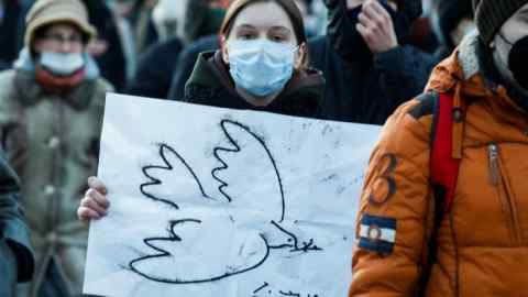 A female protester holds a picture of a dove, the symbol of peace