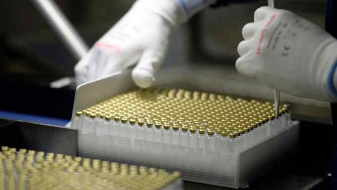 An employee checks insulin vials at a pharmaceutical factory