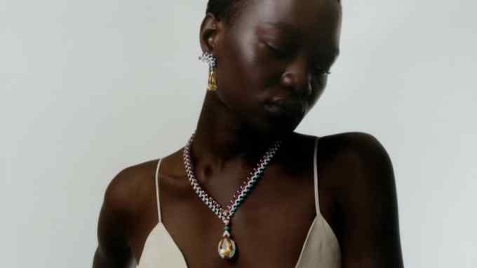 female model wearing a white dress and a necklace