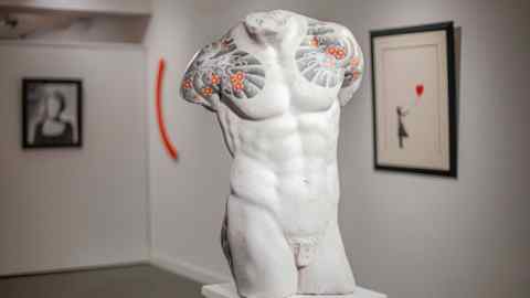Sculpture of a male torso, with tattooed shoulders