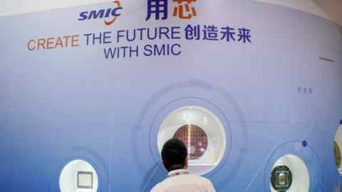 A man visits the booth of Semiconductor Manufacturing International Corporation at an expo in Shanghai