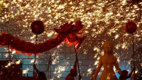 Fire dragon dancers perform under a shower of sparks from molten iron during a temple fair at the Shijingshan Amusement Park in Beijing