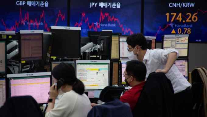 Dealers work at monitors at the Hana Bank in Seoul, South Korea