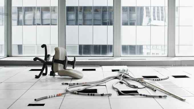 an office space littered with plastic tubes and a chair on its back