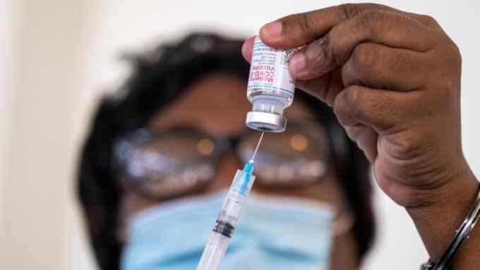 A health worker prepares a dose of the Moderna COVID-19 vaccine