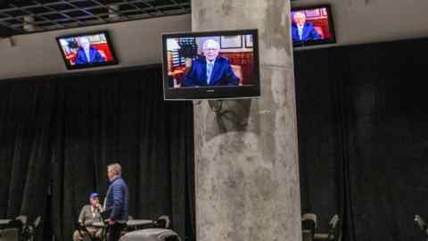 Shareholders watch television screens as Warren Buffett, chairman and chief executive officer of Berkshire Hathaway Inc., speaks