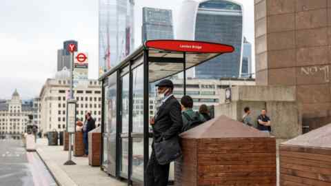 Commuter waits at a bus stop on London Bridge