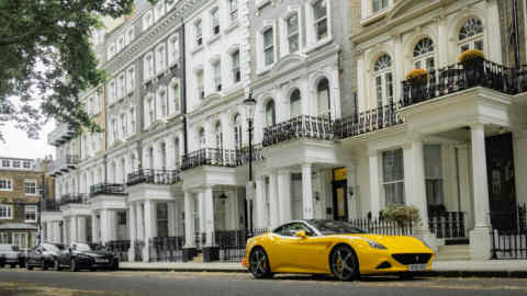 A yellow Ferrari parked in an upmarket street of townhouses in Knightsbridge