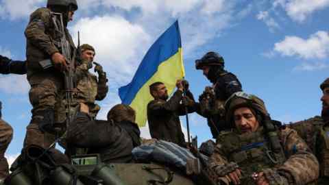 Ukrainian soldiers adjust a flag atop a personnel carrier on a road near Lyman, Donetsk, last year