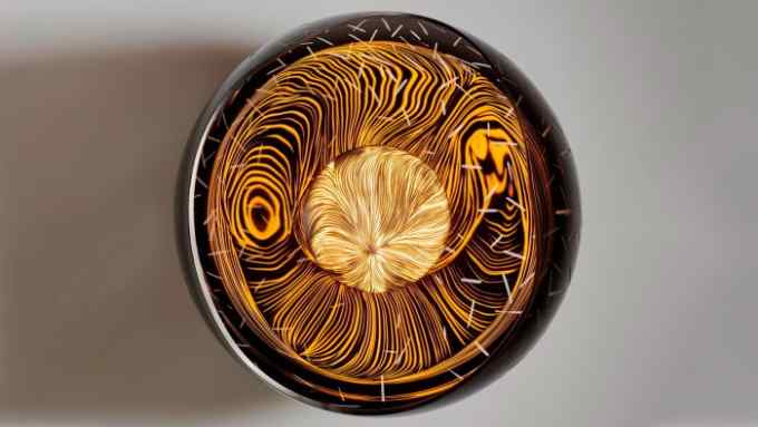 A round table seen from above. It is made from brown shades of resin and looks like an eye