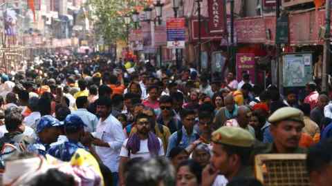 People walk along a crowded market area on the occasion of ‘Maha Shivratri’ Hindu festival in Varanasi