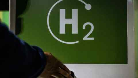 A worker prepares to fuel a Transporte Metropolitano de Barcelona (TMB) city bus at a green hydrogen refuelling station