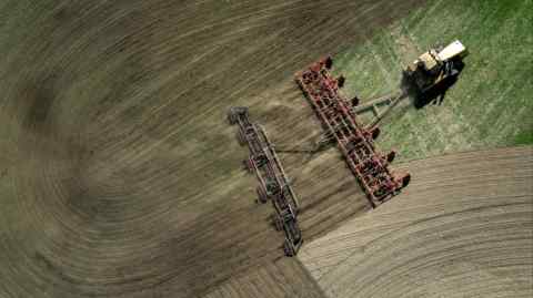 Aerial view of  tractor ploughing a field