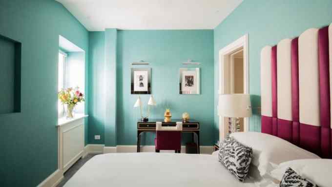 A room at Maalot Roma with pale-green walls and a lacquered black writing desk