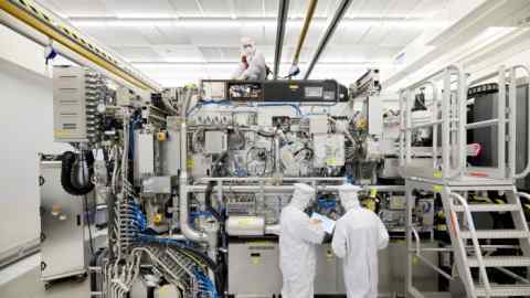 Employees work on the final assembly of ASML’s twinscan NXE:3400B semiconductor lithography tool in Veldhoven, Netherlands