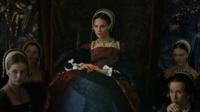 A woman in Tudor costume sits among a group of similarly dressed women