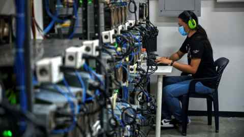 An employee inspects computers used to mine bitcoin