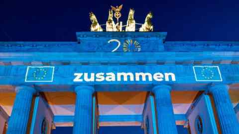 The Brandenburg Gate stands illuminated with the flag of the European Union