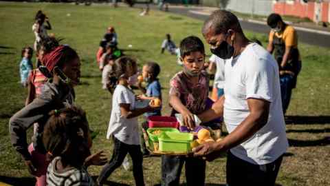 Food is distributed to children by volunteers of the Lavender Hill Sport and Recreation Foundation in Lavender Hill, Cape Town. South Africa’s lockdown has been sullied by corruption and state security violence