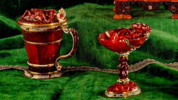 Elaborate amber tankard, cup and model cannon on luxurious green velvet