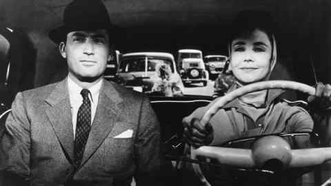 Gregory Peck in the passenger seat of a car driven by a female character in the 1956 film The Man in the Gray Flannel Suit