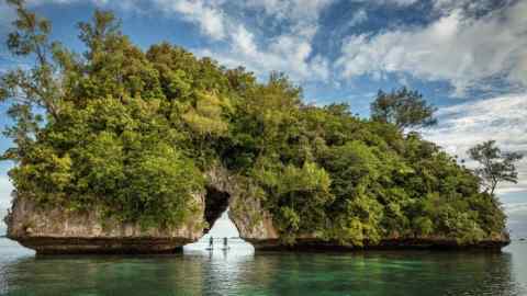 Paddleboarding in Palau off the Four Seasons Explorer catamaran