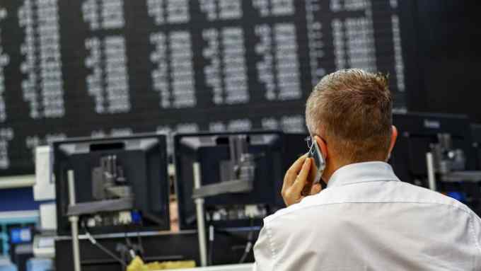 A trader speaks on a mobile phone inside the Frankfurt Stock Exchange