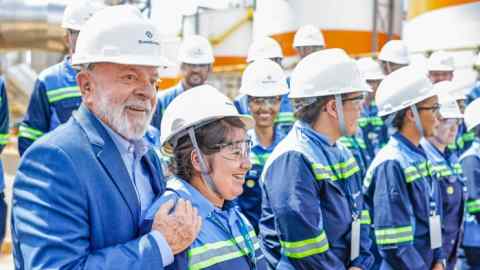 Brazil’s President Luiz Inácio Lula da Silva (leftmost) stands among workers of an industrial facility