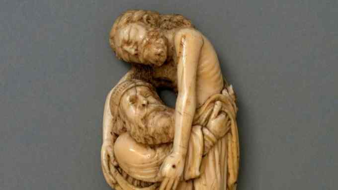 A small flat sculpture of a bearded man in a robe holding a dead man with long hair