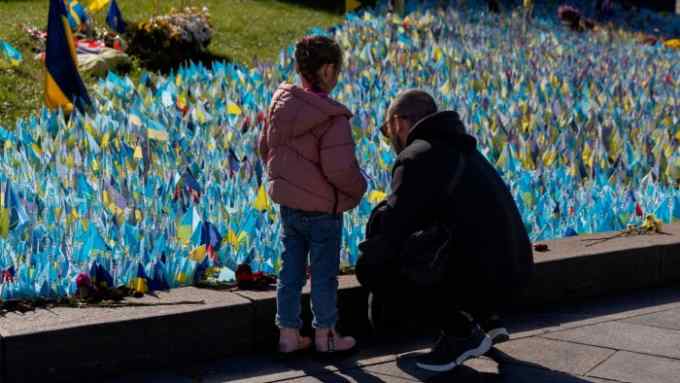 Family members near a memorial of Ukrainian soldiers killed in the country’s war against Russia on Independence square in Kyiv, Ukraine