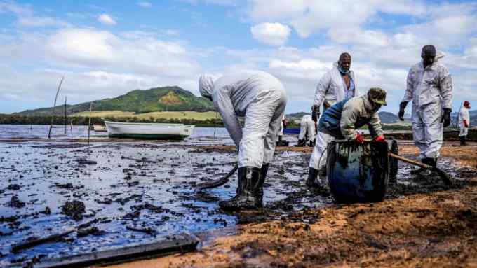 People scoop leaked oil from the vessel MV Wakashio that ran aground and caused oil leakage near Blue Bay Marine Park in southeast Mauritius on August 9, 2020