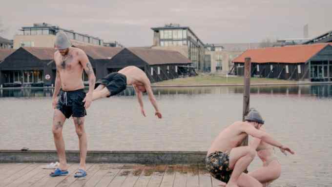 Bathers at Butcher’s Heat sauna, with one diving into a harbour pool