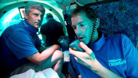 Pilot Randy Holt, right, communicates with the support boat as he and Stockton Rush, left, CEO and Co-Founder of OceanGate, dive in the company’s Antipodes submersible