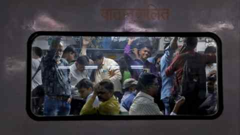Commuters travel in a crowded compartment of a suburban train in Mumbai, India